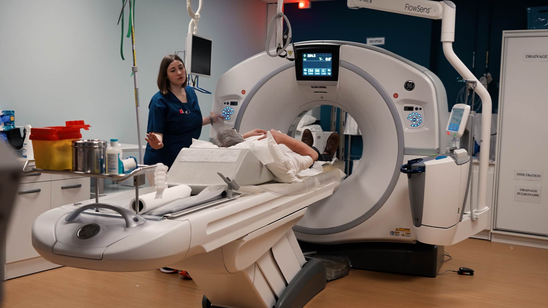 Une manipulatrice radio prend en charge un patient pour un scanner