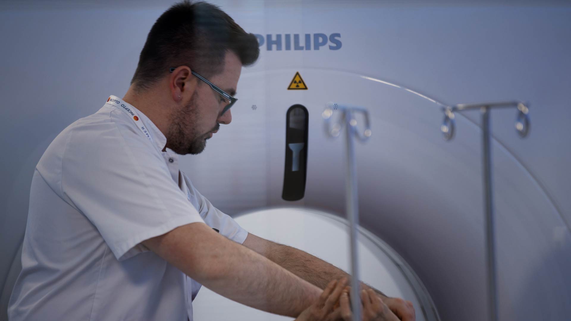 Un manip qui prend en charge un patient au Scanner